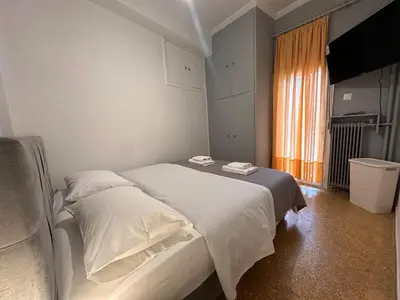 a bedroom with two beds and a window at Gazi Square Apartment in Athens