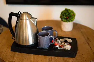 a tea kettle and cups on a tray on a table at Gazi Square Apartment in Athens