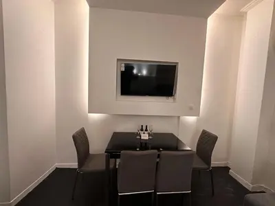 a dining room with a table and a tv on a wall at Gazi Square Apartment in Athens