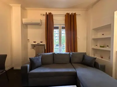a living room with a couch and a window at Gazi Square Apartment in Athens