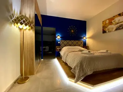 a bedroom with a bed and a blue wall at Glyfada SEASIDE South Athens Philoxenia In Athens in Athens