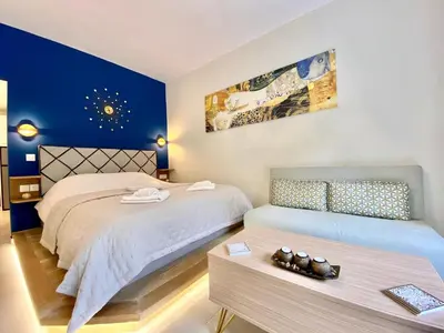 a bedroom with two beds and a table with a bed sidx sidx sidx at Glyfada SEASIDE South Athens Philoxenia In Athens in Athens