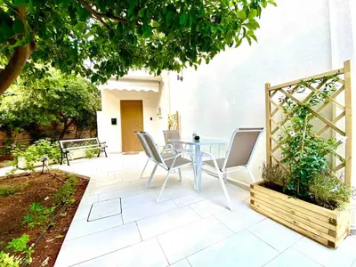 a patio with a table and chairs under a tree at Glyfada SEASIDE South Athens Philoxenia In Athens in Athens
