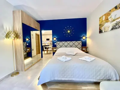 a bedroom with a large bed with blue walls at Glyfada SEASIDE South Athens Philoxenia In Athens in Athens