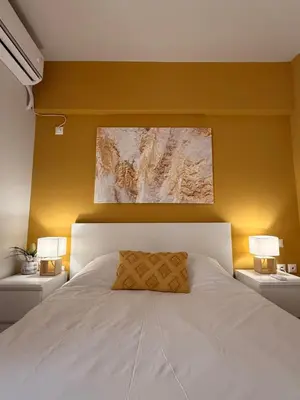 a bedroom with a white bed with two lamps at ArtemisAth in Athens