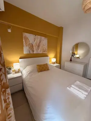 a bedroom with a white bed with two night stands at ArtemisAth in Athens