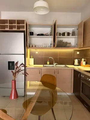 a kitchen with a glass table and a refrigerator at ArtemisAth in Athens
