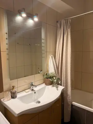 a bathroom with a sink and a mirror and a tub at ArtemisAth in Athens