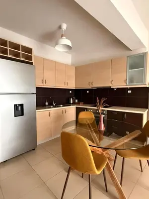 a kitchen with a glass table and a refrigerator at ArtemisAth in Athens