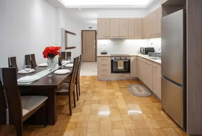 a kitchen with a table and chairs and a refrigerator at Charming Apt Near Athens Museum! in Athens