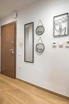 a hallway with a door and two mirrors on a wall at Elegant, Spacious and hitech apt at Koukaki in Athens