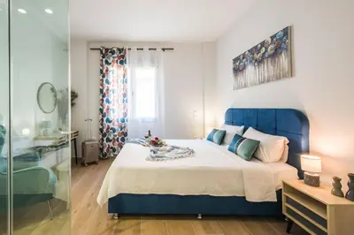 a bedroom with a blue bed and a glass shower at Elegant, Spacious and hitech apt at Koukaki in Athens