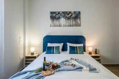 a bed with a blue headboard with a tray of flowers on it at Elegant, Spacious and hitech apt at Koukaki in Athens