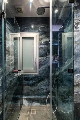 a bathroom with a shower with a glass door at Elegant, Spacious and hitech apt at Koukaki in Athens