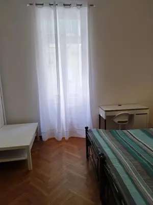 a bedroom with a bed and a table and a window at Rental room pilika4 in Athens