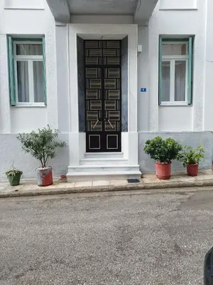 a front door of a white house with potted plants at Rental room pilika4 in Athens