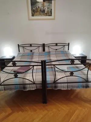 a large bed in a room with a wooden floor at Rental room pilika4 in Athens
