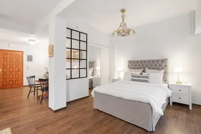 a white bedroom with a large bed and a table at Unique apartment next to Acropolis and metro in Athens
