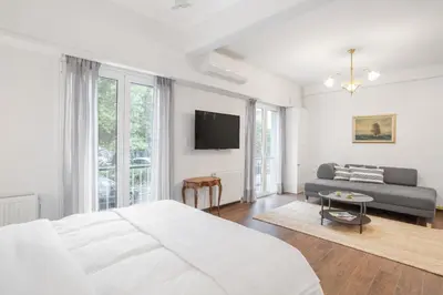 a white bedroom with a bed and a couch at Unique apartment next to Acropolis and metro in Athens