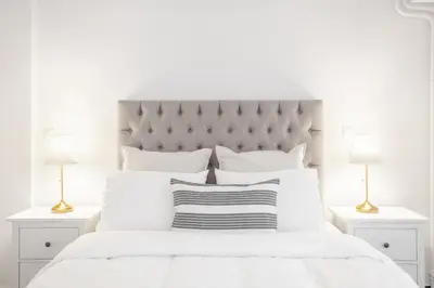 a white bedroom with a large white bed with two lamps at Unique apartment next to Acropolis and metro in Athens