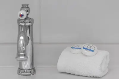 a bathroom sink with a faucet and two cups at Unique apartment next to Acropolis and metro in Athens