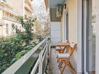 a balcony with two chairs and a table on a building at Stunning apartment next to Acropolis and metro in Athens