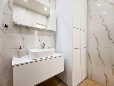a white bathroom with a sink and a mirror at Stunning apartment next to Acropolis and metro in Athens