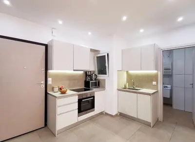 a kitchen with white cabinets and a sink at Stunning apartment next to Acropolis and metro in Athens