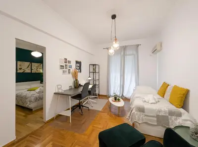 a bedroom with a bed and a desk in it at Spacious apt for 5 guests next to Acropolis&metro in Athens