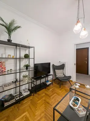 a living room with a television and a chair at Spacious apt for 5 guests next to Acropolis&metro in Athens