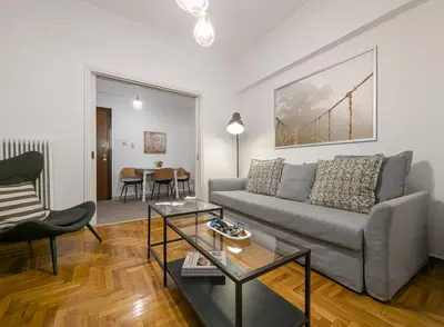 a living room with a couch and a table at Spacious apt for 5 guests next to Acropolis&metro in Athens