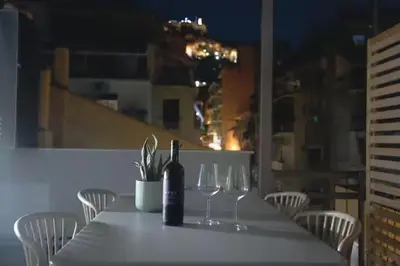 a table with a bottle of wine and two wine glasses at Modern apartment with Great view in Athens