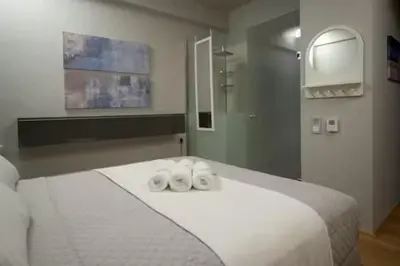 a bedroom with a white bed with two towels on it at Modern apartment with Great view in Athens