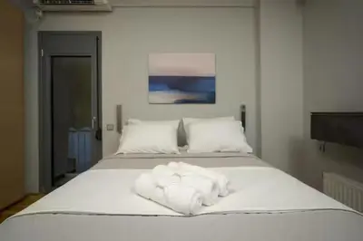 a large white bed with white sheets and pillows at Modern apartment with Great view in Athens