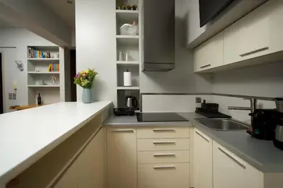 a kitchen with white cabinets and a sink at Modern apartment with Great view in Athens