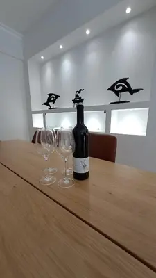 a bottle of wine sitting on a table with two wine glasses at Athens Riviera Bee Home Appartments in Athens