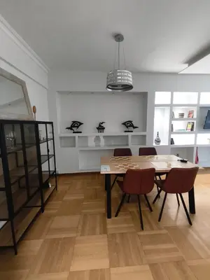 a dining room with a table and chairs and shelves at Athens Riviera Bee Home Appartments in Athens