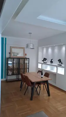 a dining room with a wooden table and chairs at Athens Riviera Bee Home Appartments in Athens