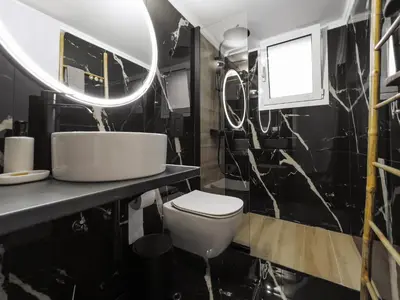 a bathroom with a white toilet and a mirror at Cosy Home Thissio in Athens