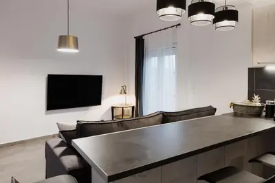a living room with a table and chairs and a tv at Cosy Home Thissio in Athens