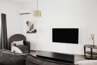 a living room with a couch and a tv on a wall at Cosy Home Thissio in Athens