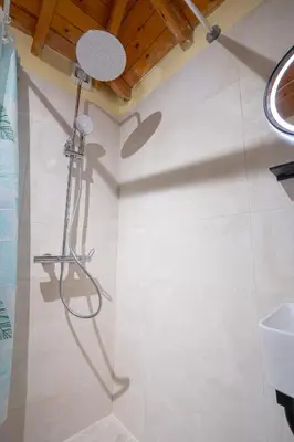 a shower in a bathroom with a white tiled wall at Monastiraki metro st 1 bedroom apt for 2 by MPS in Athens