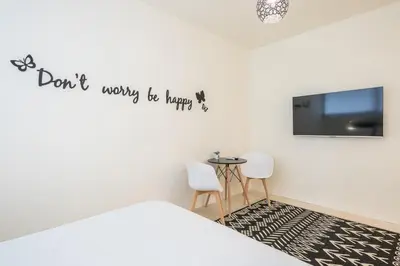 a bedroom with a bed and a tv and a table at Syrou 1834 in Athens