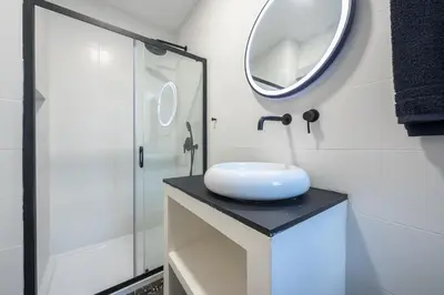 a bathroom with a white sink and a mirror at Syrou 1834 in Athens