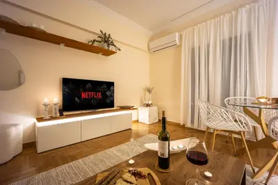 a living room with a television and a bottle of wine at Cozy Apartment - Best Location in Athens in Athens