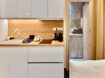 a kitchen with white cabinets and a sink at Ermou 18 Central Cozy Apartment in Athens