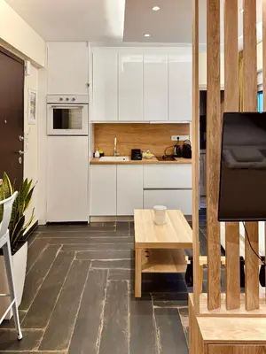 a kitchen with white cabinets and a wooden table at Ermou 18 Central Cozy Apartment in Athens