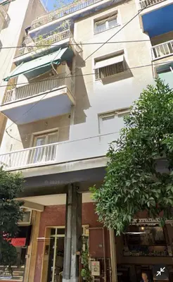 a white building with a tree in front of it at Infinity penthouse in Koukaki in Athens