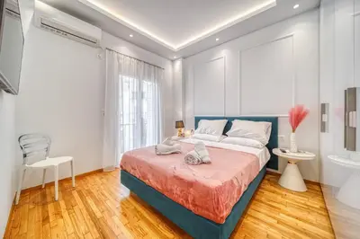 a bedroom with a blue bed and a bathroom at Infinity penthouse in Koukaki in Athens
