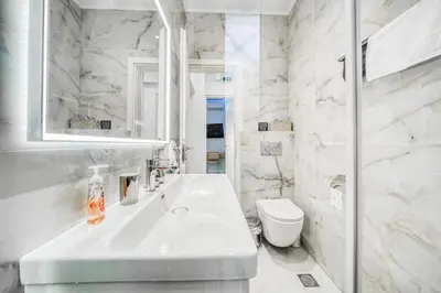a white bathroom with a sink and a toilet at Infinity penthouse in Koukaki in Athens